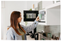 Uma jaqueta de couro marrom, com zíperes e botões prateados, é exibida contra um fundo cinza simples. Esta jaqueta clássica estilo biker ostenta uma cintura com cinto e fecho de zíper assimétrico, incorporando uma moda atemporal.